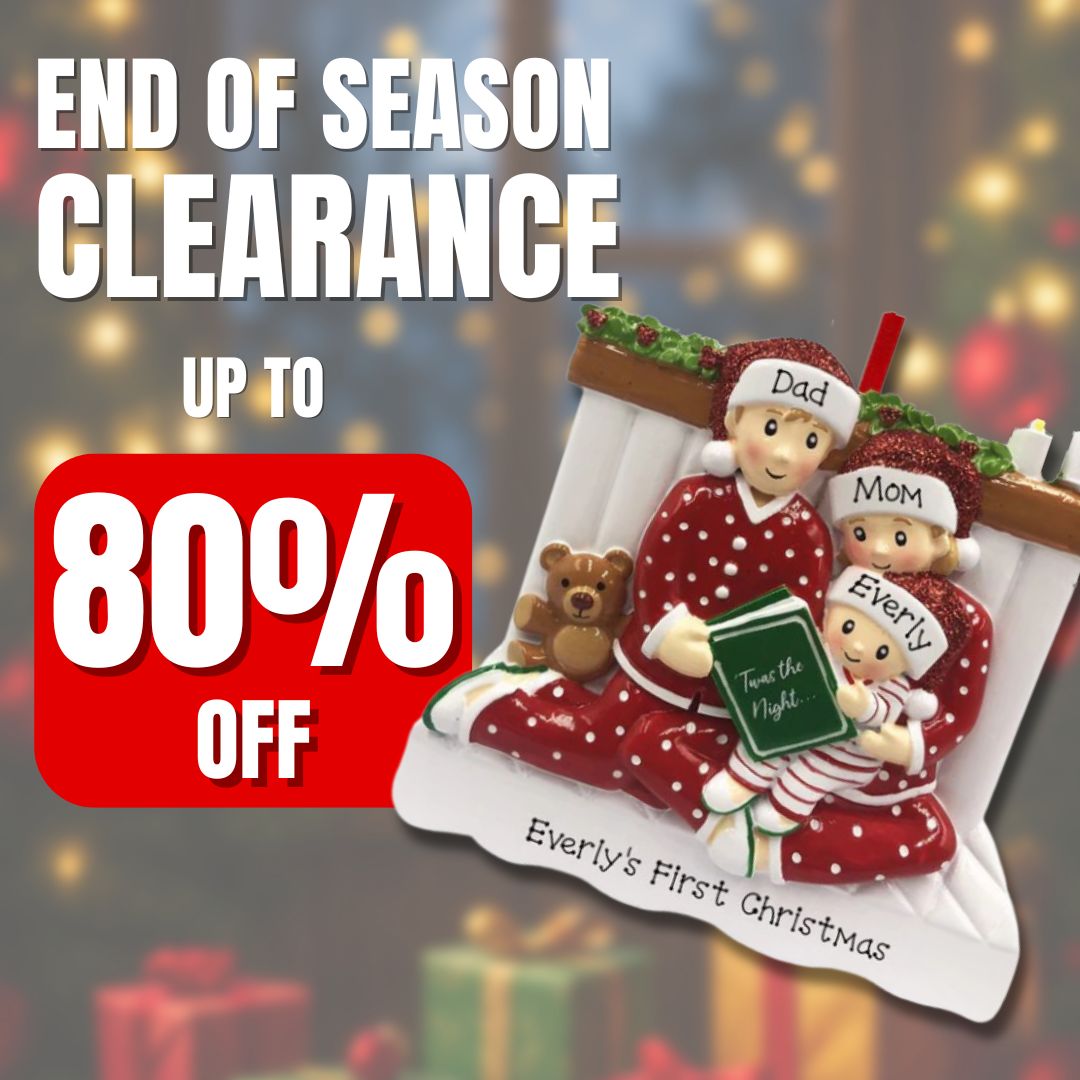 Personalized family ornament with ‘Dad,’ ‘Mom,’ and ‘Everly’ in matching pajamas, reading by the fireplace. Part of OrnamentShop’s up to 80% off clearance sale.