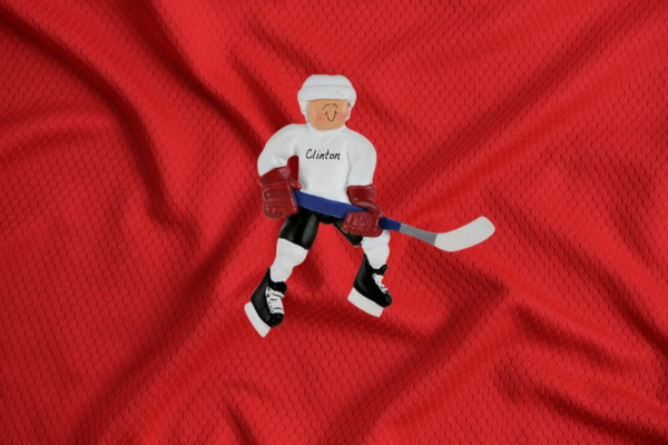 Youth hockey player personalized ornament holding a hockey stick in full gear.
