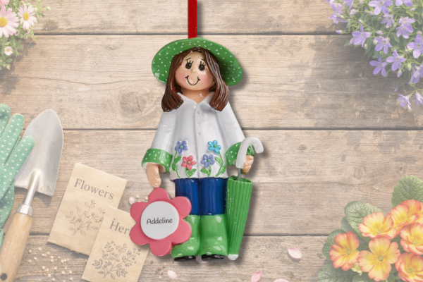 Personalized gardening ornament featuring gardener with flowers, rain boots, and umbrella holding custom name.