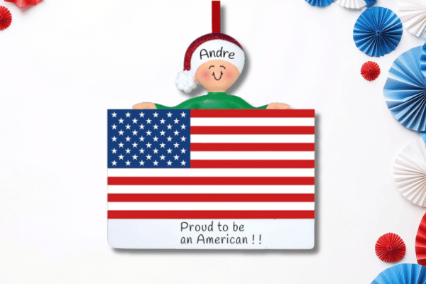 Personalized patriotic ornament featuring American flag design, custom name, and “Proud to be an American” message.