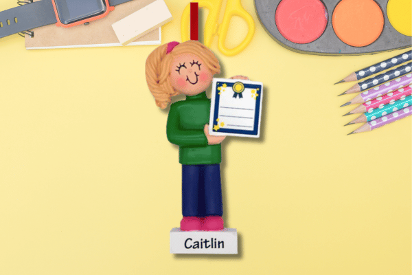 Personalized school achievement ornament featuring student figurine holding certificate, custom name on base.