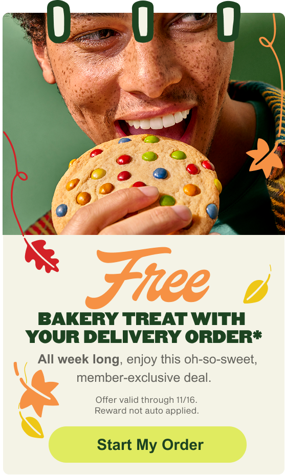 A MyPanera promotional banner featuring a smiling man holding a large, colorful sugar cookie topped with chocolate candies. The text advertises a Free BAKERY TREAT WITH YOUR DELIVERY ORDER*, a week-long, member-exclusive deal valid through 11/16, with a Start My Order button at the bottom.