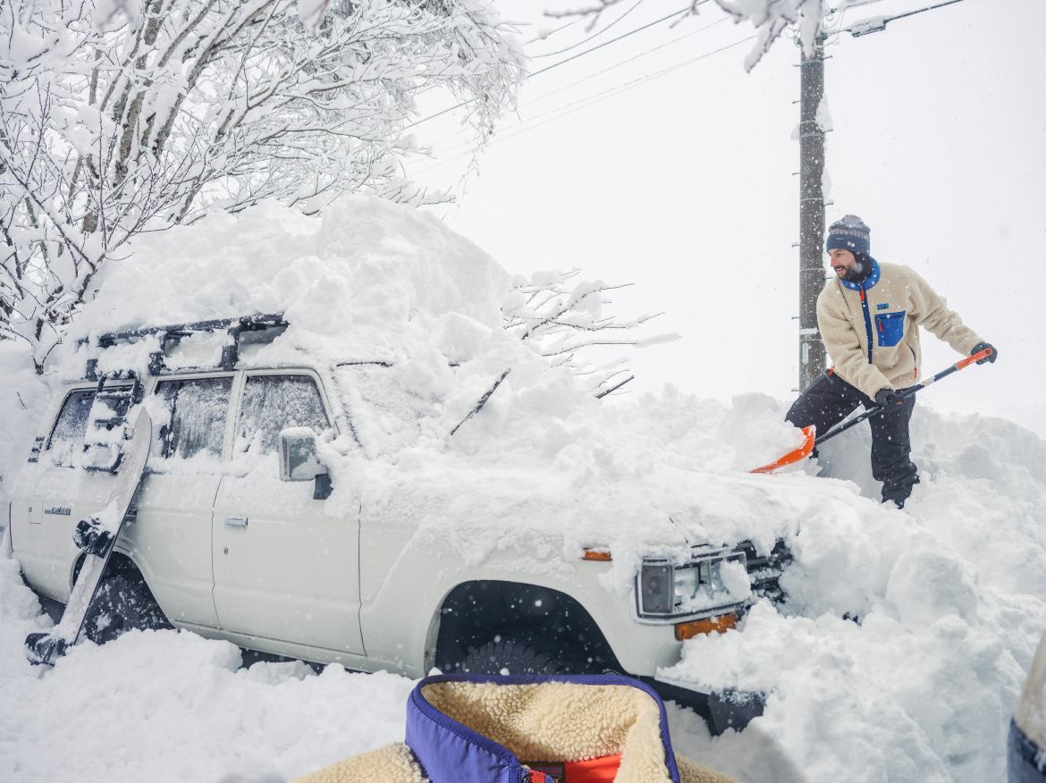 Patagonia. A person shoveling snow away from a car