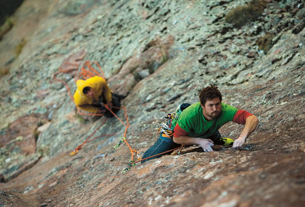 Two people climb a rock.