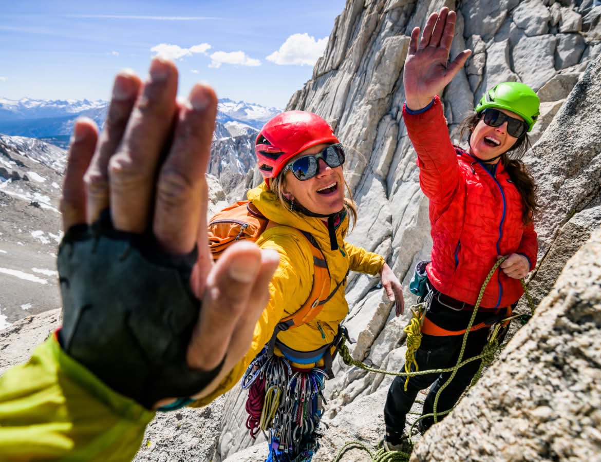 Three climbers sharing high fives.
