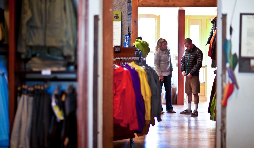 A customer tries on a jacket inside of a Patagonia store.