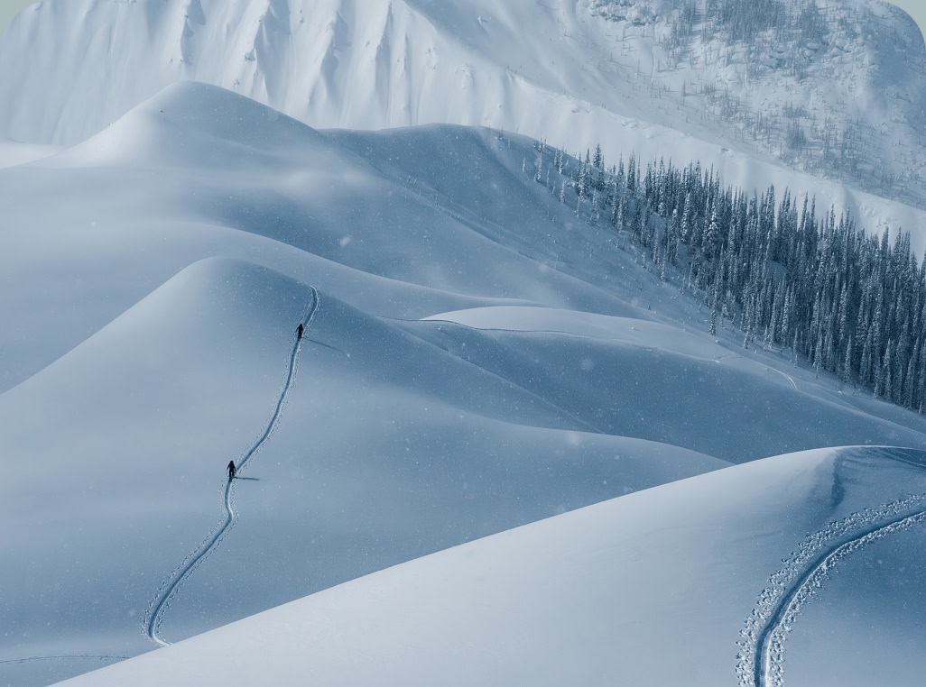 Two skiers on a long and snowy skintrack.