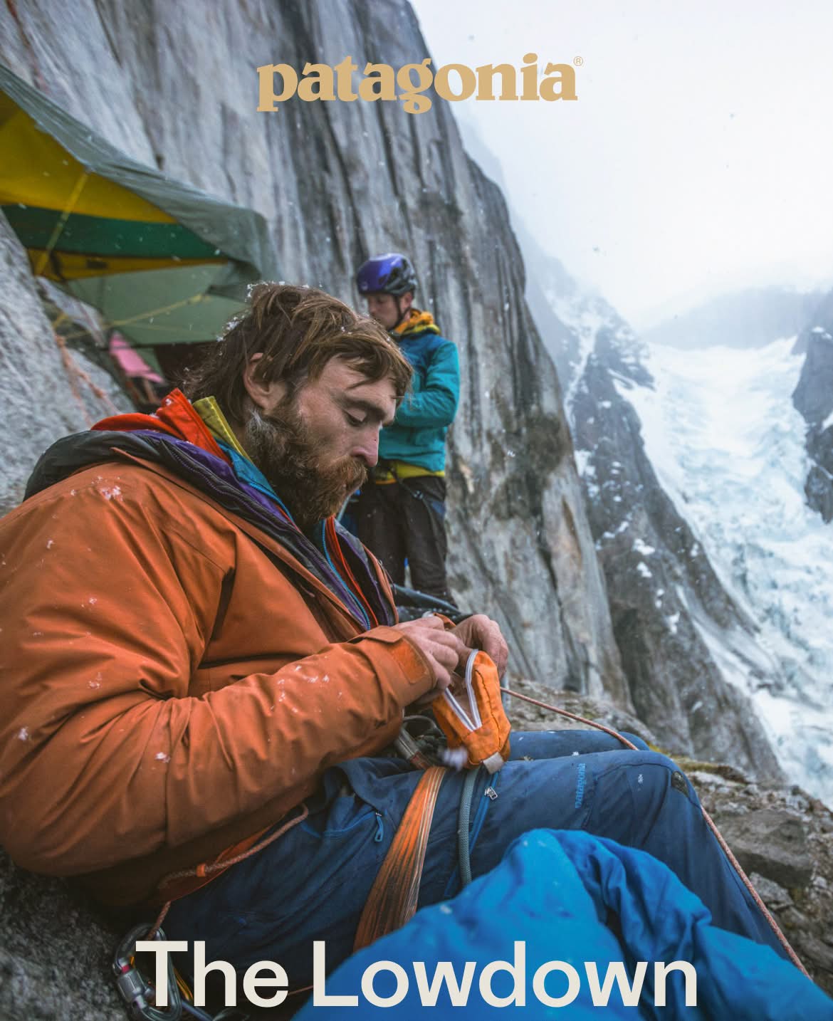 Patagonia. The Lowdown on Layering. Two people set up camp on a snowy cliff.