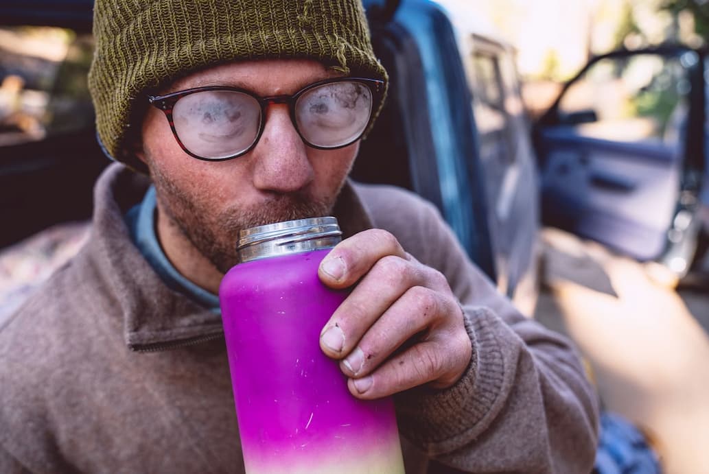 Patagonia. Sweaters for Going Full Steam. A person’s glasses are fogged up from sipping a hot drink.