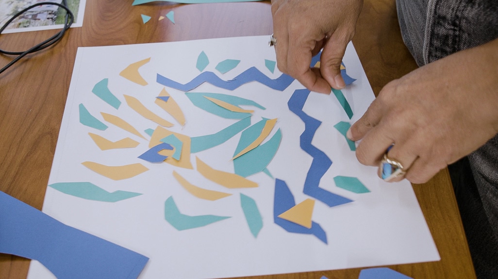 A designer creates a print with paper cut outs.