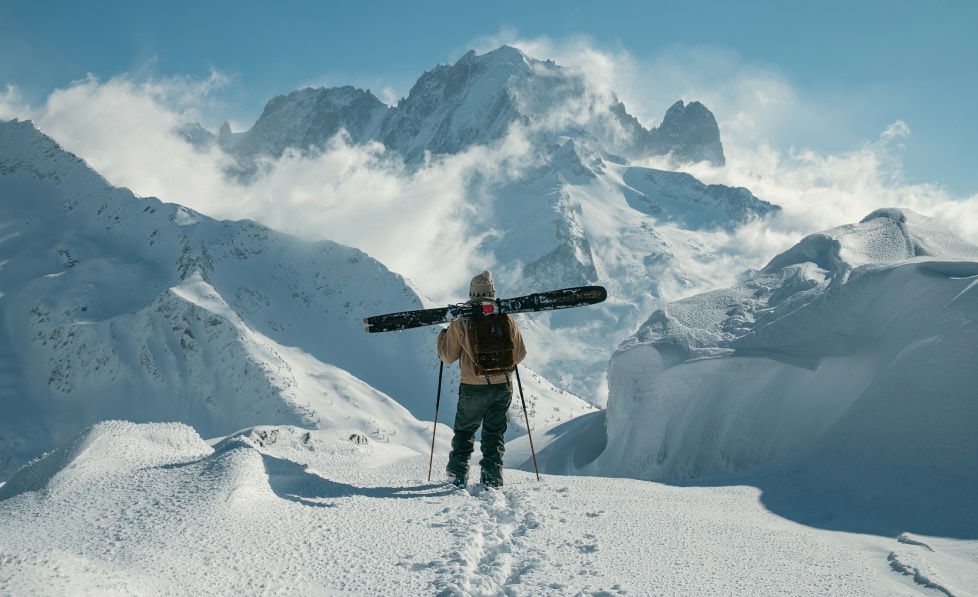  backcountry skier gazes at a huge mountain range before dropping in. 