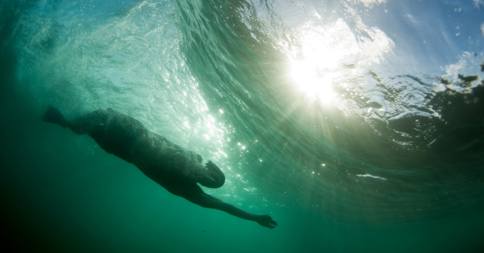 A bodysurfer dives beneath a wave.