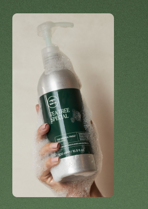 image of a hand holding Tea Tree Special Aluminum Shampoo Bottle
