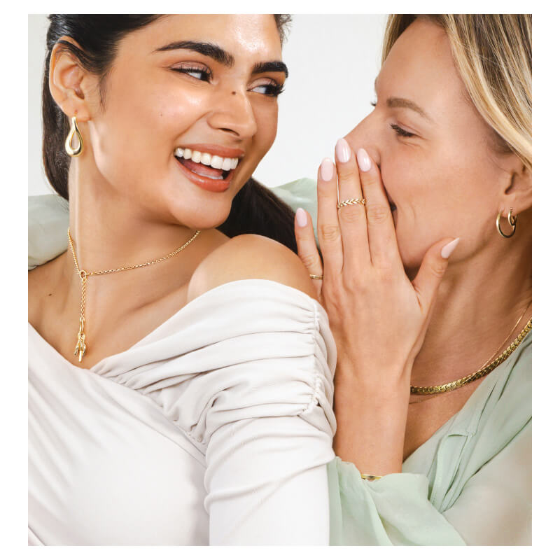 Two women pose, showcasing stunning Gold Necklaces, Earrings and Rings