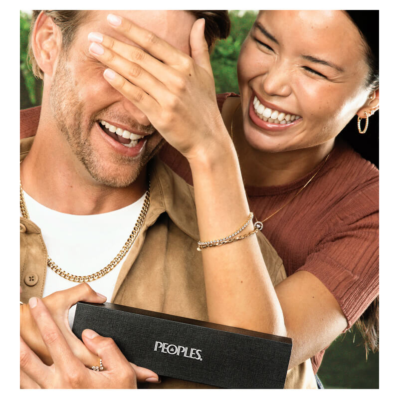 A smiling couple pose, showcasing stunning Gold Necklaces, Earrings and Bracelets