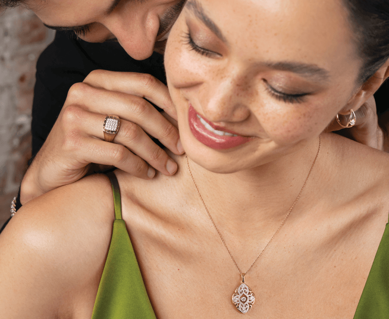 Man adjusting beautiful woman's elegant necklace.