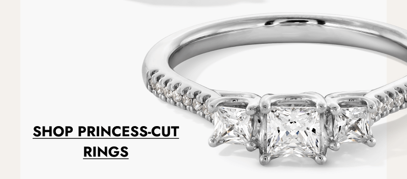 Princess-cut three-stone diamond engagement ring on a white gold band. Click shop princess-cut rings.