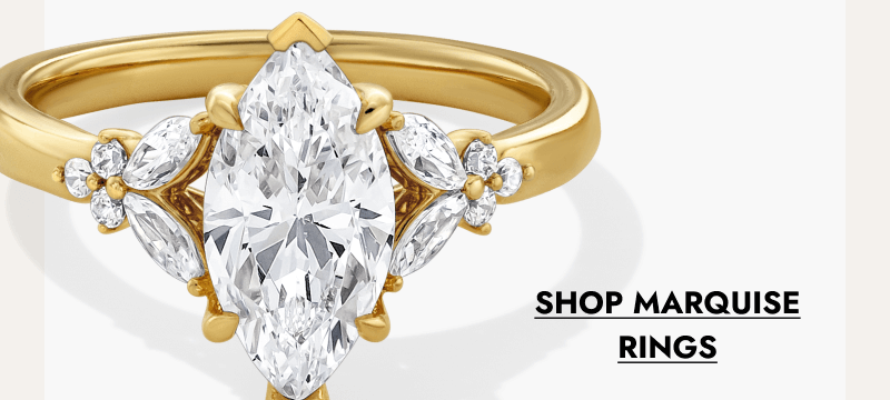 Marquise-cut diamond engagement ring with side stones on a yellow gold band. Click shop marquise rings.