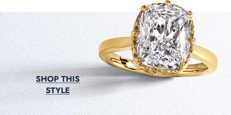 Yellow gold cushion-cut diamond solitaire engagement ring.