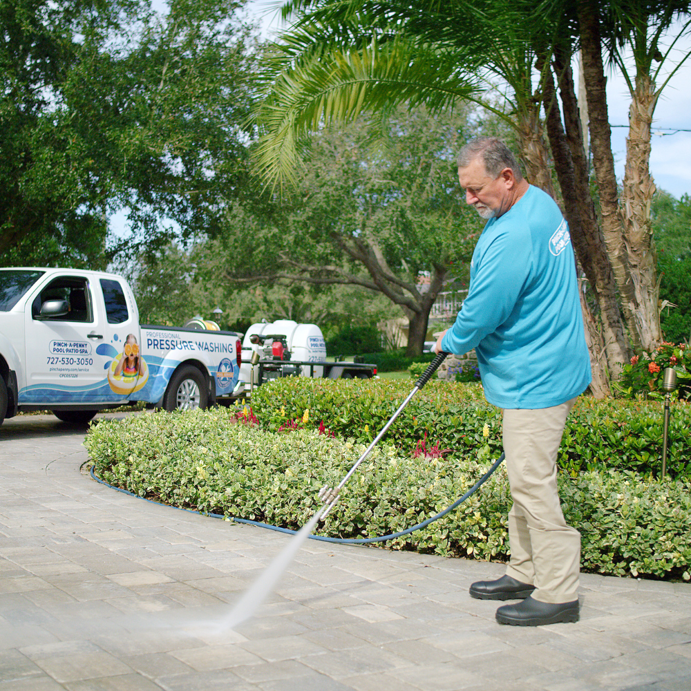 man pressure washing driveway