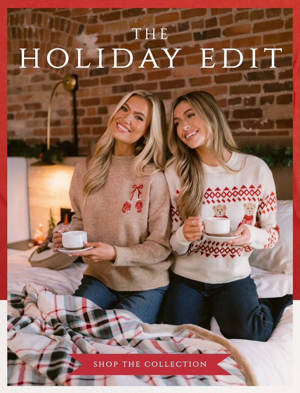'The Holiday Edit.' Image of models sitting in a bed wearing Christmas sweaters, cozy vibes. Button: 'Shop the Collection.'