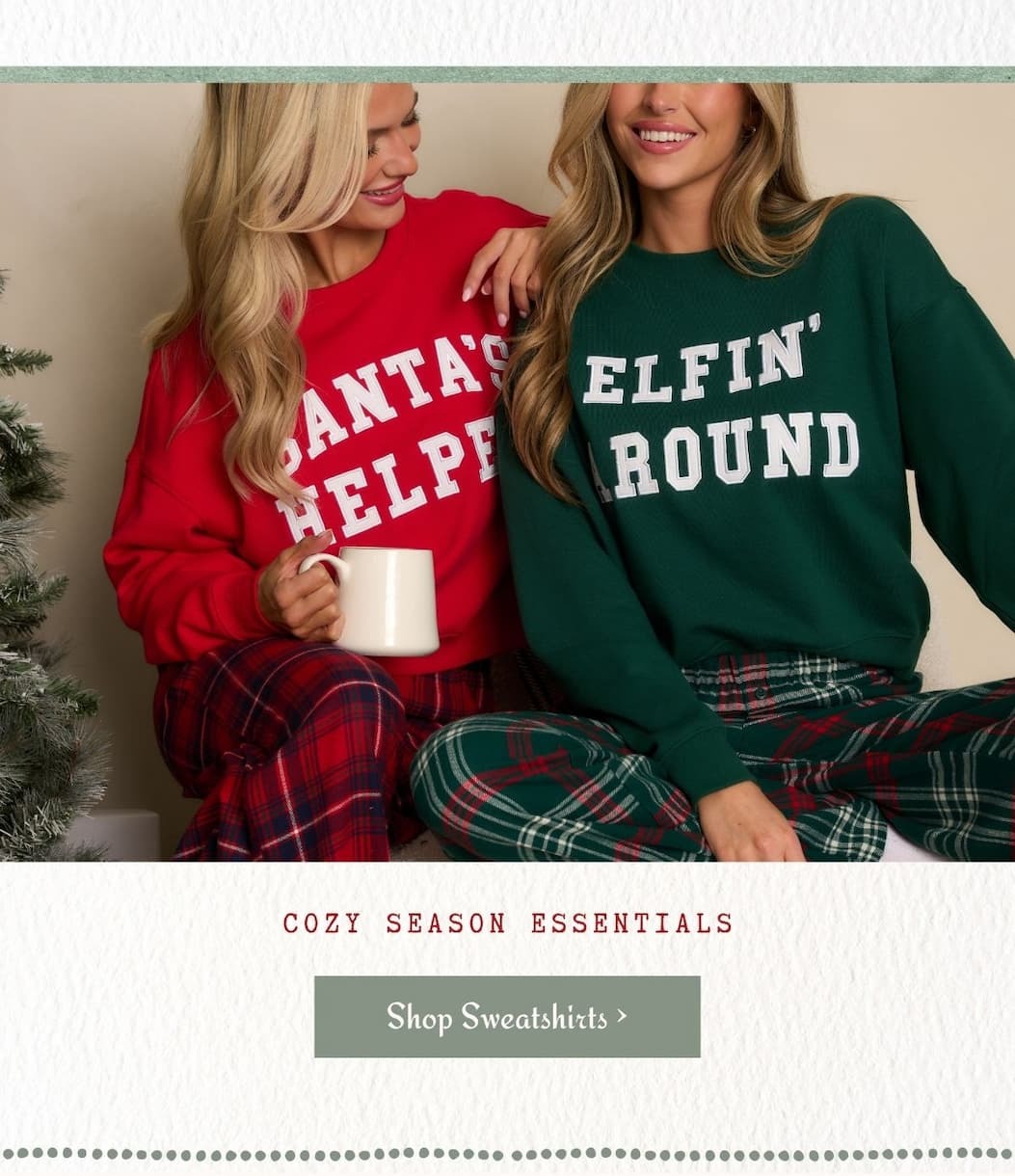 Image of models wearing Christmas themed sweatshirts. 'Cozy Season Essentials.' Button: 'Shop Sweatshirts.'