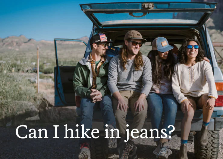 Group of hikers wearing jeans sits in the back of a truck. Headline: Can I hike in jeans?