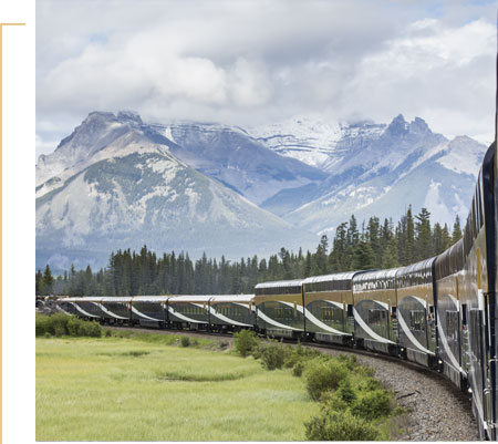 Rocky Mountaineer travelling through mountain scenery.