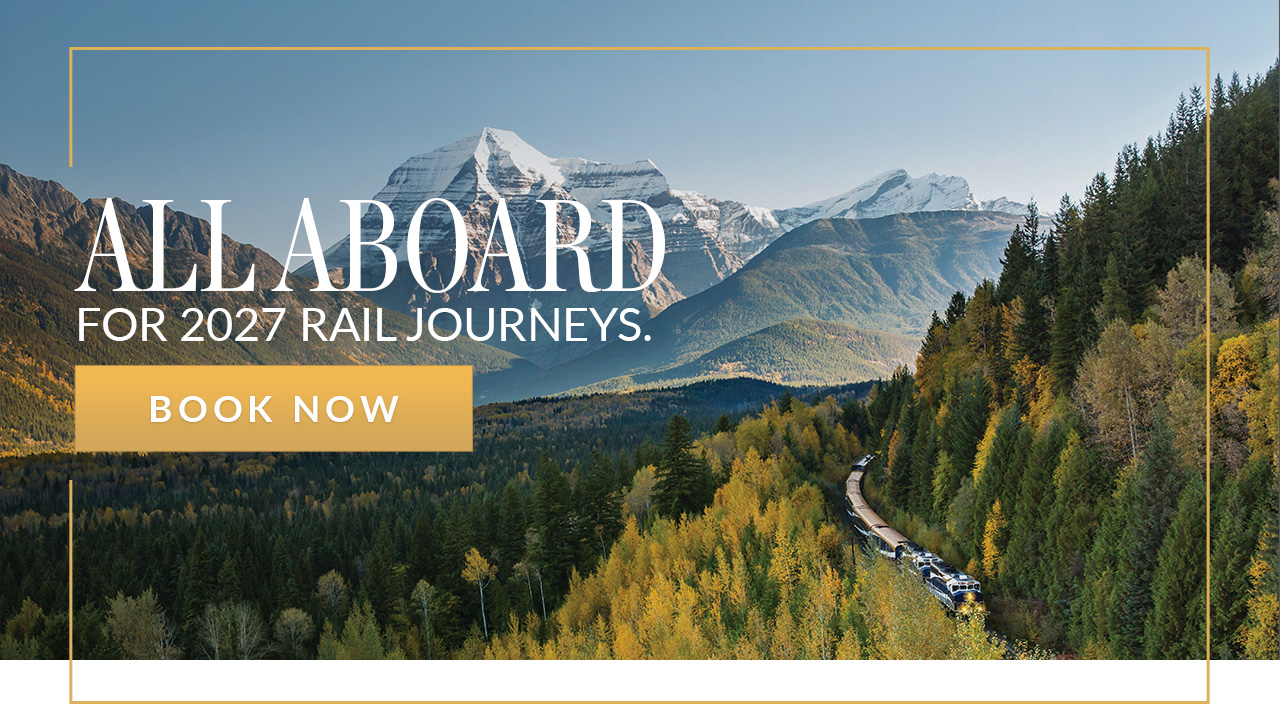 Rocky Mountaineer train travelling through a forest with Mount Robson above.