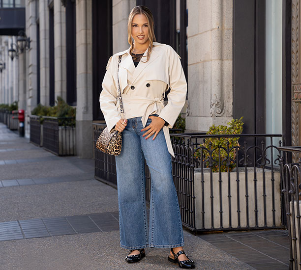 Woman wearing a cropped trench coat and wide leg jeans from Ross.