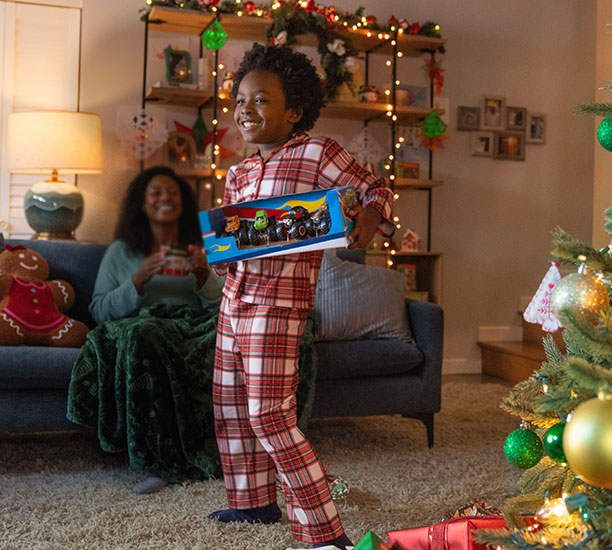 Boy dancing with his new brand name monster trucks from a Ross store. 