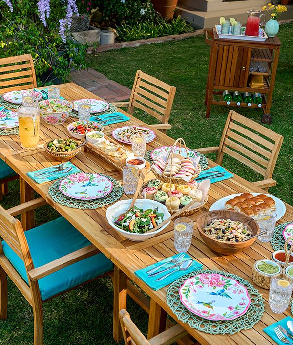 Outdoor table settings with teal placemats and hummingbird printed plates. 