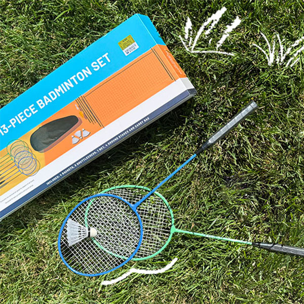 Blue and green rackets and badminton set laid on grass.  