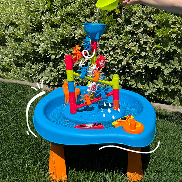 Blue, red, and green kids water table and toys in backyard.&nbsp;
