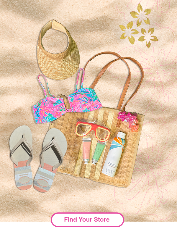 Beach bag essentials lay down of swimsuit top, goggles, sunscreen, flower clip. 