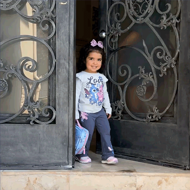 Girl smiling and showing Disney’s Lilo and Stitch lunch pail and outfit. 