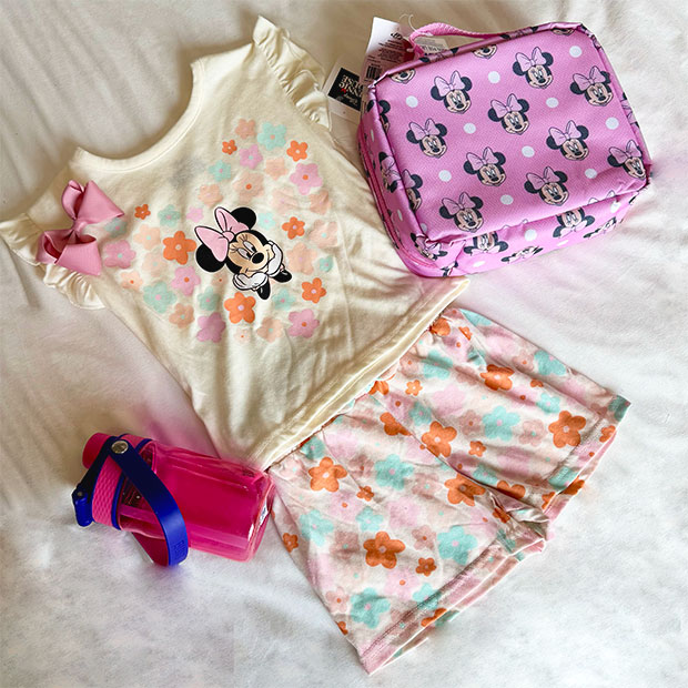 Pink floral Disney’s Minnie Mouse shorts summer outfit with lunch pail and water bottle.