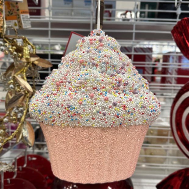Cupcake-shaped ornament with a pink base and white frosting covered in colorful sprinkles found in store at Ross. 
