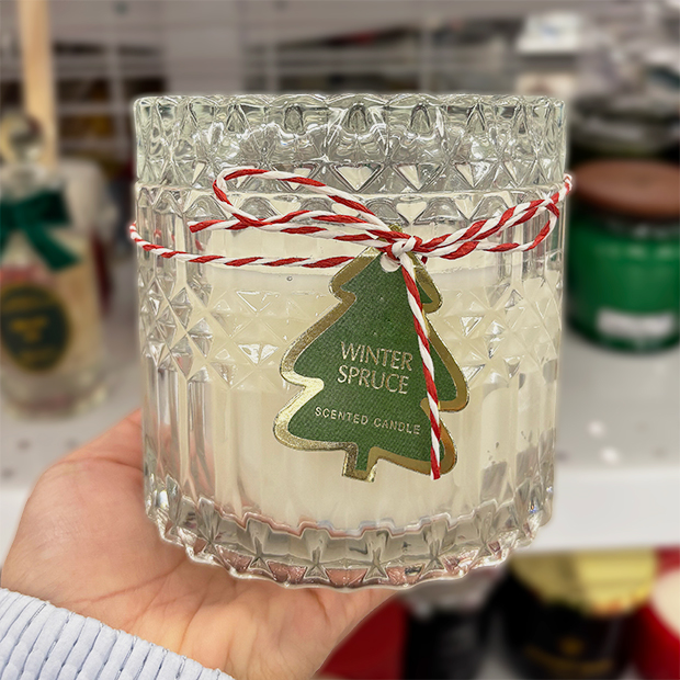 Clear textured glass jar candle with a green tree-shaped tag reading 