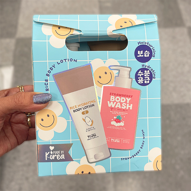 Blue gift box featuring Rice Hydrating Body Lotion and Strawberry Body Wash with cheerful smiley flower design. 