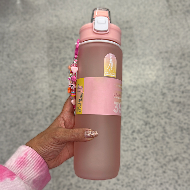 Pink reusable water bottle with flip‑top lid and decorative charm, found in store at Ross. 