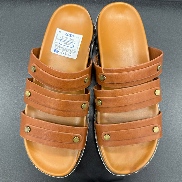 Tan slide sandals with three horizontal straps secured by brass-tone rivets and a contoured footbed. 