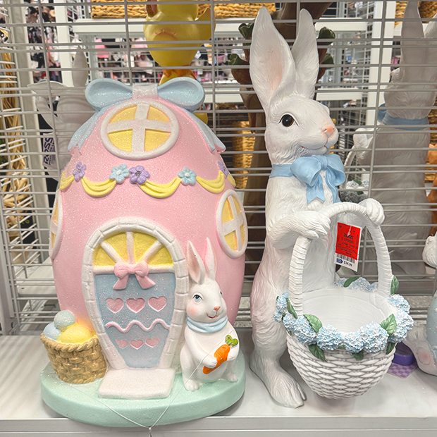 Two pastel Easter house decorations with cupcake-style roofs, bunny accents, and egg details displayed on a store shelf.