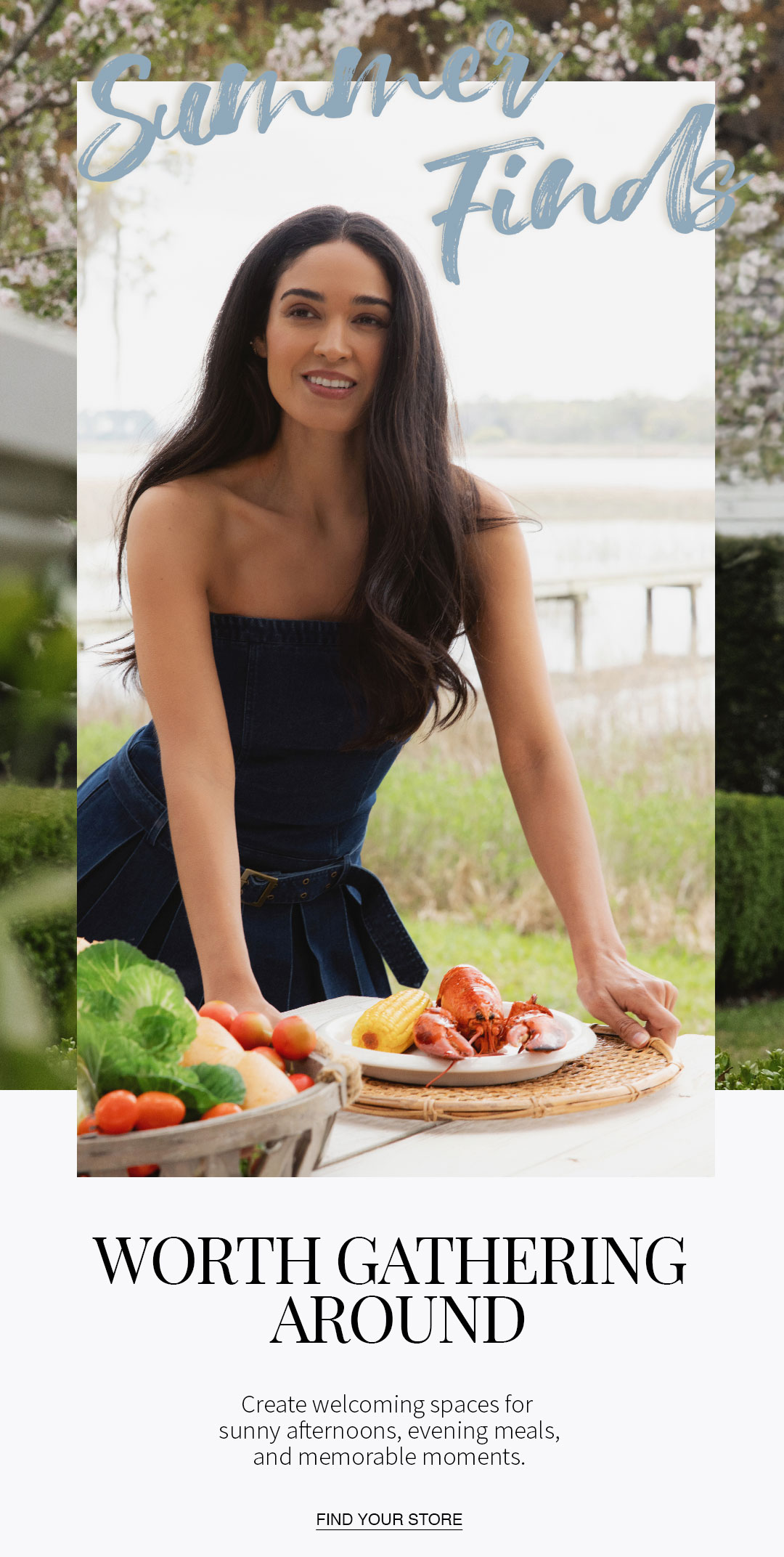 A person standing at an outdoor table set with lobster, corn, and fresh vegetables in a garden setting. Text reads: “Summer Finds. Worth Gathering Around. Create welcoming spaces for sunny afternoons, evening meals, and memorable moments.”