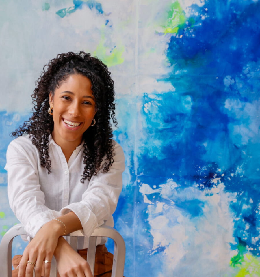 artist smiling in front of a canvas