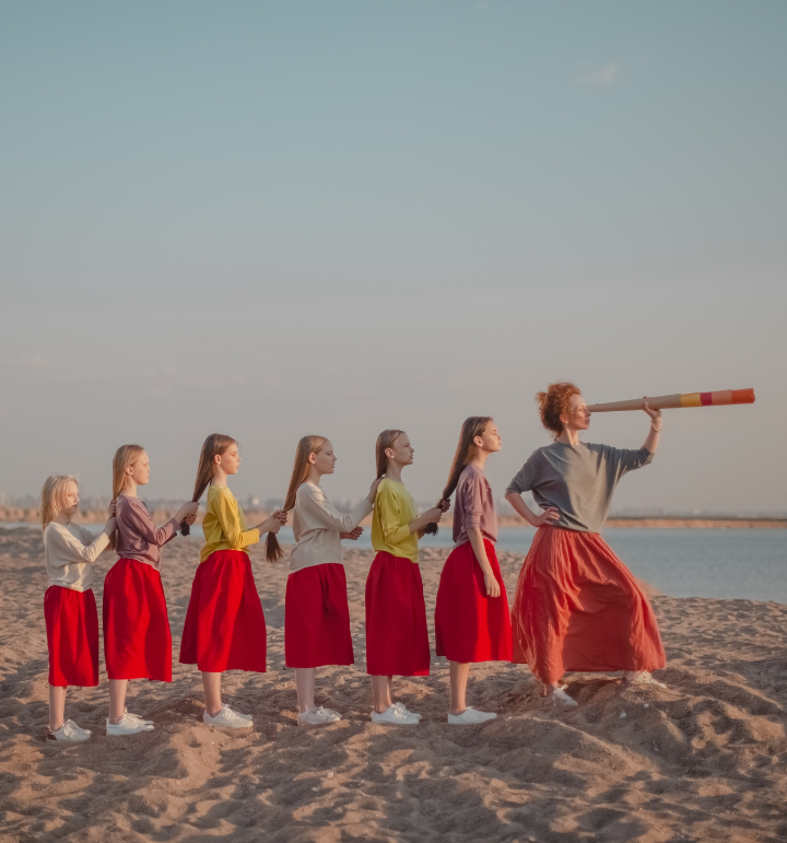 Photograph of girls on beach in red skirts