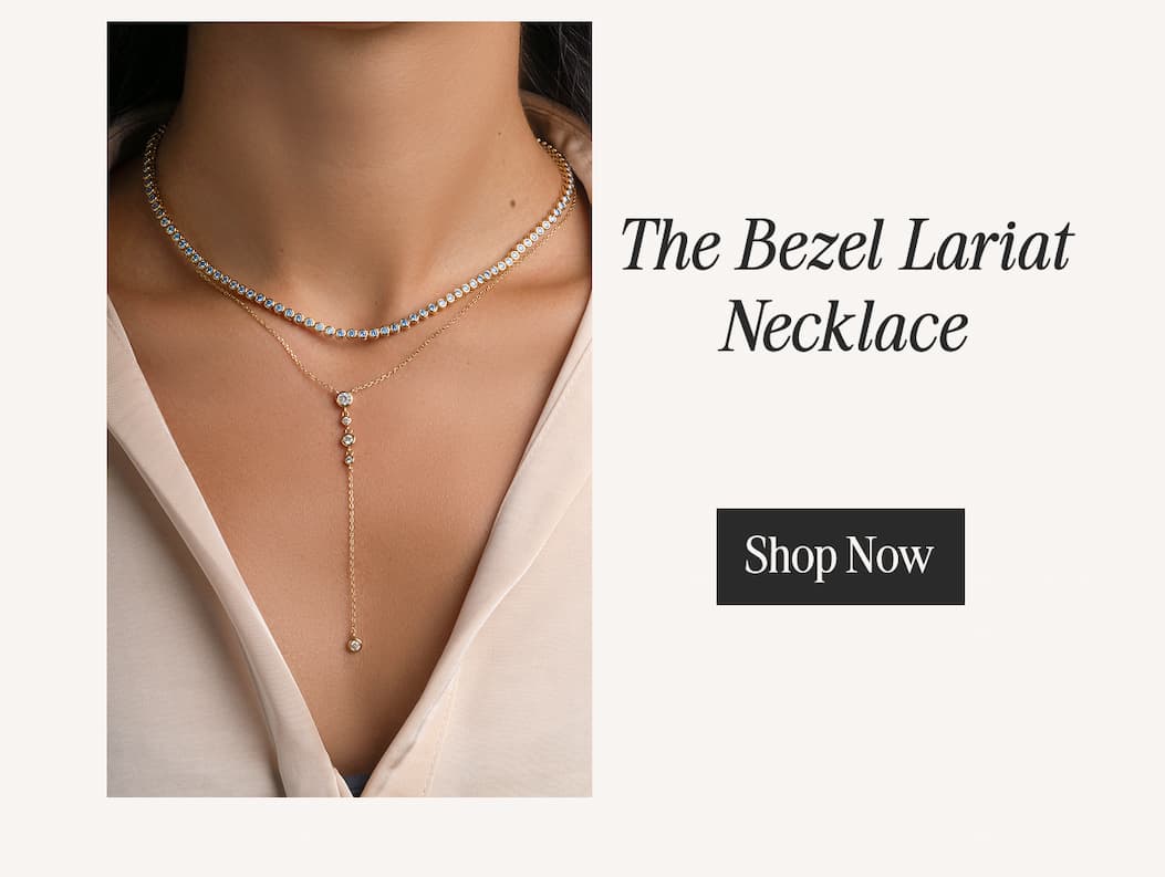 The Bezel Lariat Necklace layered with a tennis necklace — gold Y-chain with bezel-set stones. Shop Now.