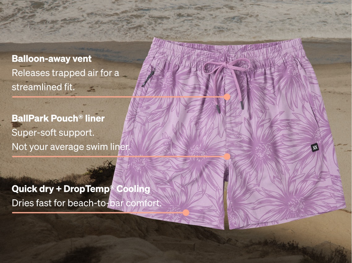 Men’s floral swim shorts with labeled features including quick-dry fabric, DropTemp cooling, and BallPark Pouch liner on a beach background