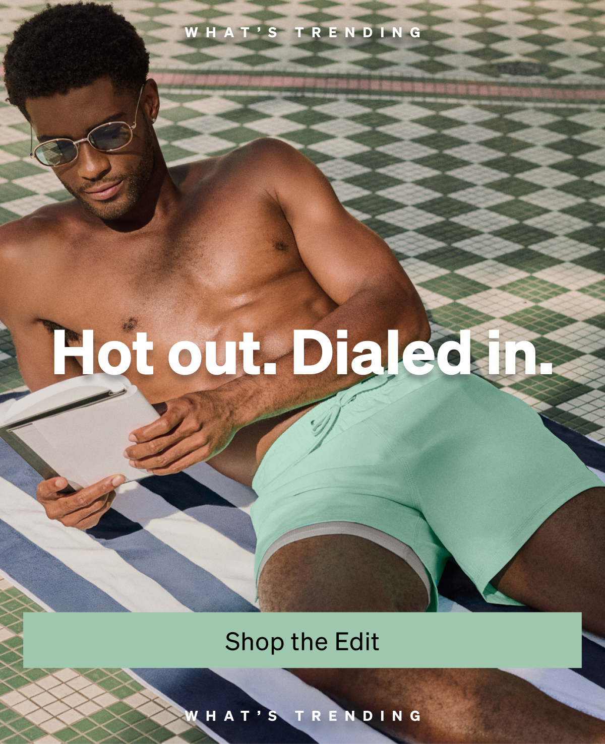 Man lounging poolside in mint green swim shorts with “Hot out. Dialed in.” text overlay