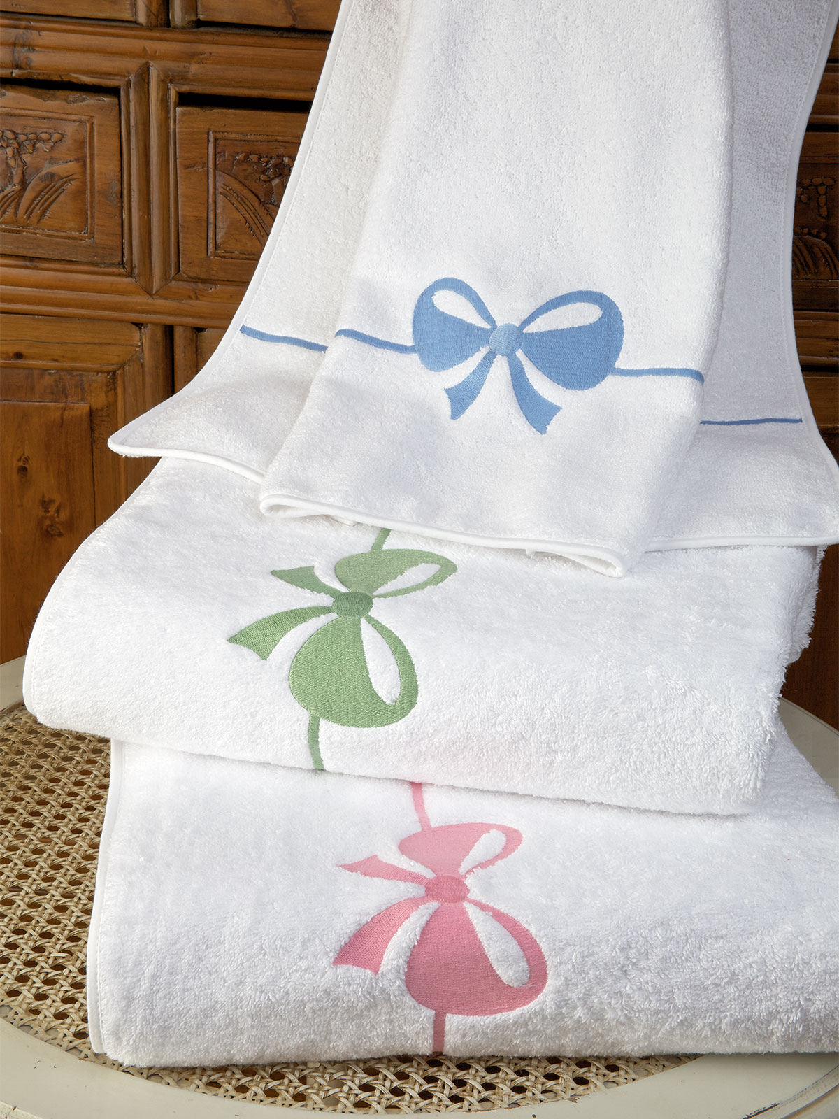 luxurious White 100% cotton terry, with embroidered bow-tied ribbon.